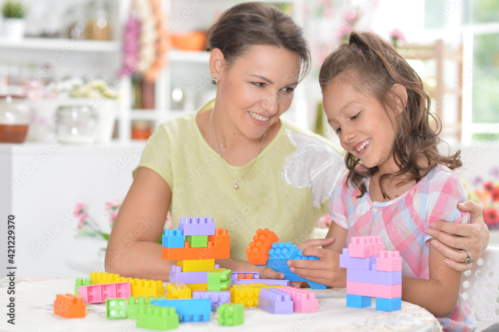 Young mother and little daughter playing blocks game Young mother and little daughter playing blocks game