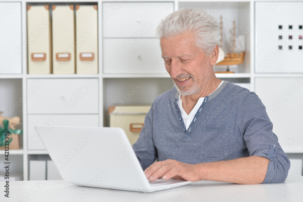  senior man using laptop at home