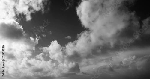 Timelapse of white cumulus obscuring the sky. Black and white 4K footage clip.