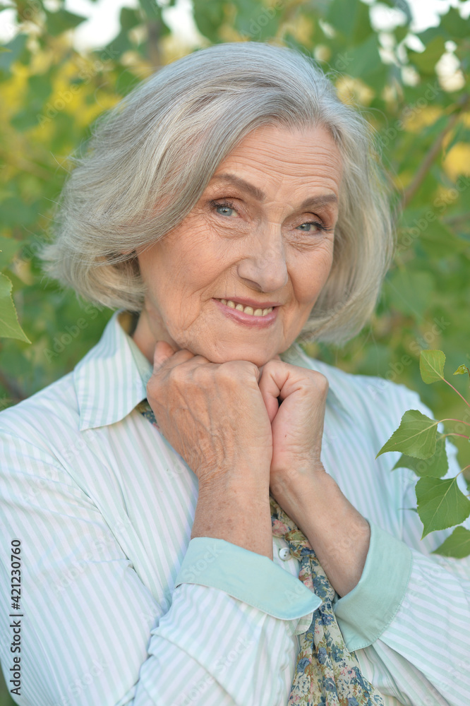 Portrait of a happy smiling senior woman in park Portrait of a happy smiling senior woman in park