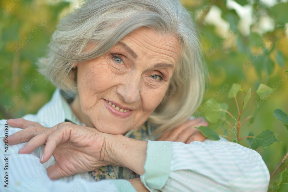 Portrait of a happy smiling senior woman in park Portrait of a happy smiling senior woman in park
