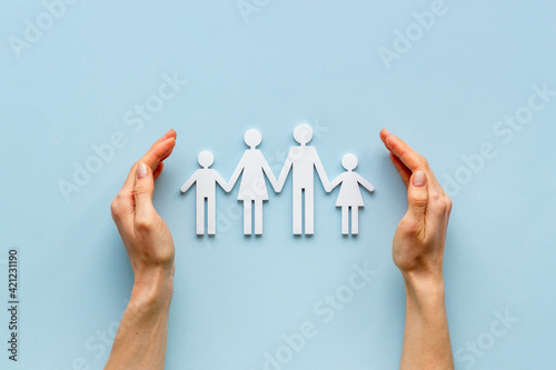 Fotografie Hands holding family figure top view. Insurance concept