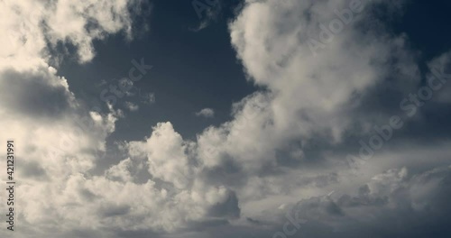 Timelapse of white cumulus obscuring the sky. Duotone, blue and yellowish 4K footage.