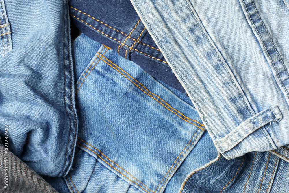 Top view of blue jeans in different shades and textures. Denim background. Top view of blue jeans in different shades and textures. Denim background.