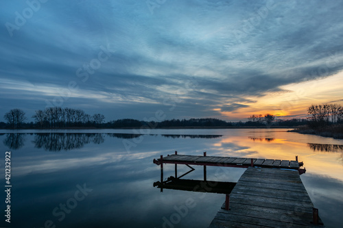 Wooden fishing pier and beautiful evening clouds over the lake, Stankow, Poland