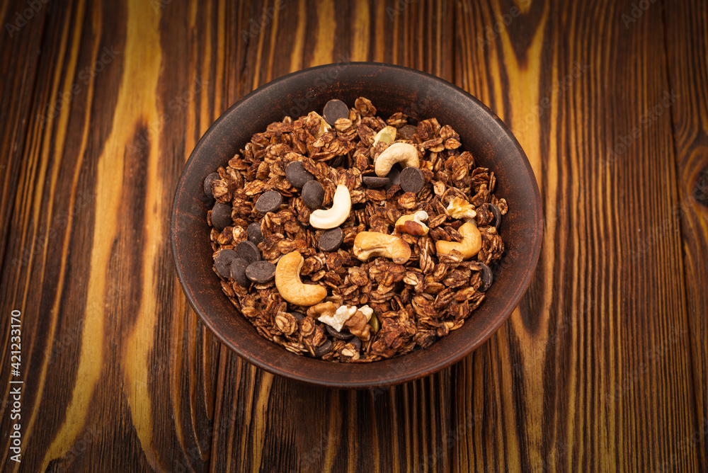 Chocolate granola cereal with nuts in a bowl. Chocolate granola cereal with nuts in a bowl.