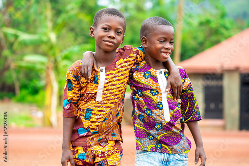 Foto image of two young african kids holding each other- cheerful black boys- outdoor