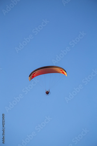 paraglider flying with paramotor on sunset