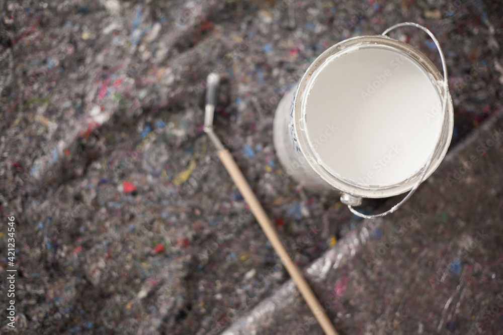 Paint buckets and painting accessories are laid out on painted fleece