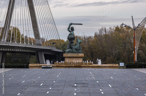 Monument of Mermaid on a boulevards over Vistula River in Warsaw, view with Swietokrzyski Bridge, Poland