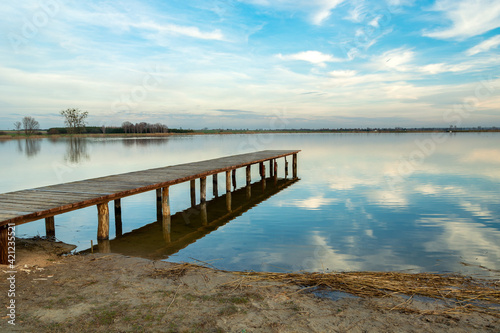 Wallpaper Mural Long wooden jetty towards a calm lake, reflection of the clouds in the water Torontodigital.ca