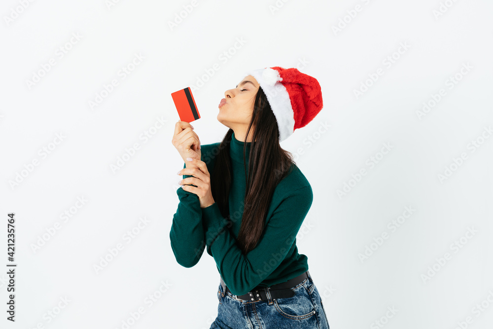 Young woman wearing red santa hat holds plastic bank card Young woman wearing red santa hat holds plastic bank card