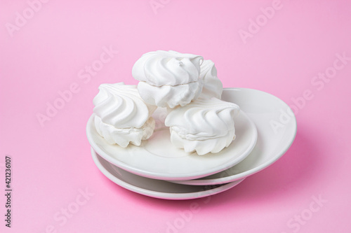 White marshmallow on a pink background. White marshmallow on a white plate. Light dessert