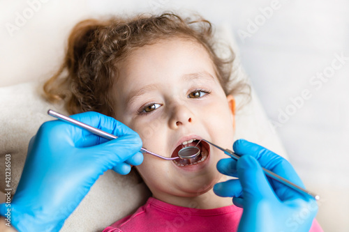 examination  treatment teeth children. medical checkup oral cavity with instruments. dental hands  child in clinic. Cute girl smiling stomatology. kid in dentist chair. concept health  medicine