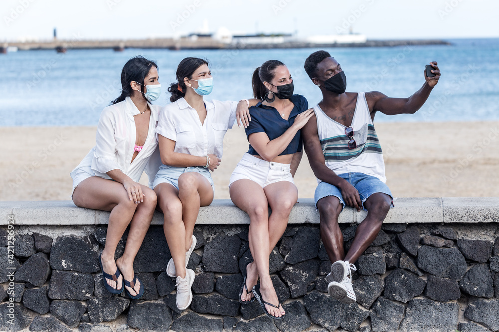 Fototapeta premium Company of multiethnic friends taking selfie on embankment