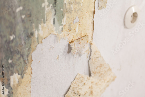 Interior wall with woodchip wallpaper remnants during the renovation electrical outlet repairing cables laying rented apartment investing painting trade expertise old building old town apartment diy © michelsass