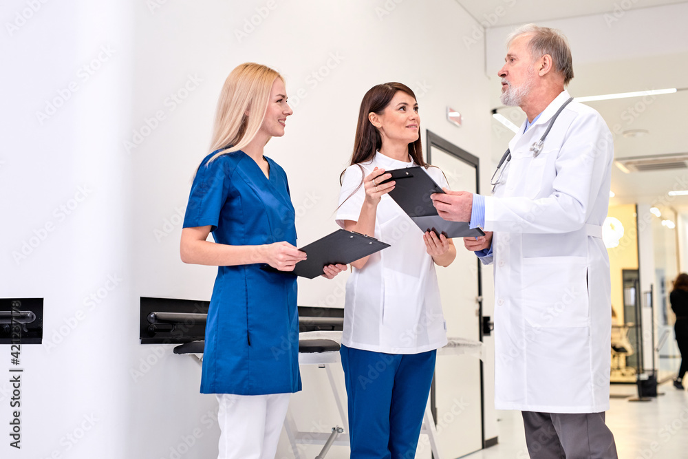 Doctor giving his younger colleagues a piece of advice concerning the diagnosis Doctor giving his younger colleagues a piece of advice concerning the diagnosis