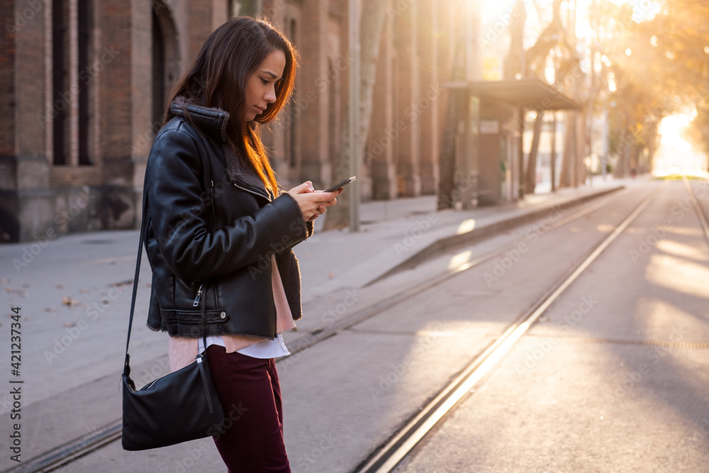 woman texting on phone while crossing the street woman texting on phone while crossing the street