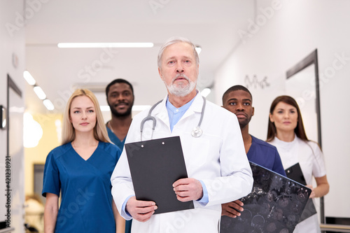 Group of doctors at head of senior caucasian doctor