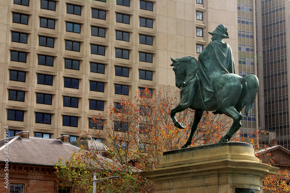 Sydney, NSW Australia. High-rise Sydney hotel, sandstone buildings and a of bronze statue features King Edward VII in uniform on horseback looking at the hotel - obrazy, fototapety, plakaty 