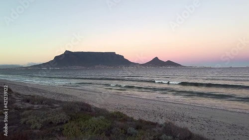 4K aerial drone beach footage of a silhouetted Table Mountain