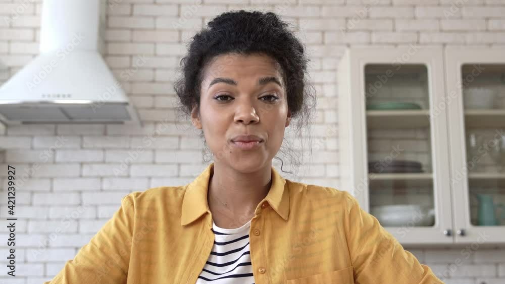 african american woman waving hand during video conference at home