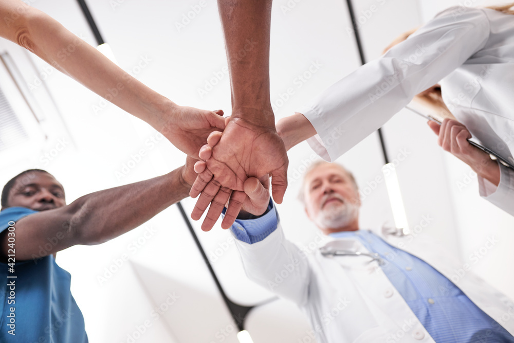 bottom view. interracial group of medical colleagues putting their hands together bottom view. interracial group of medical colleagues putting their hands together