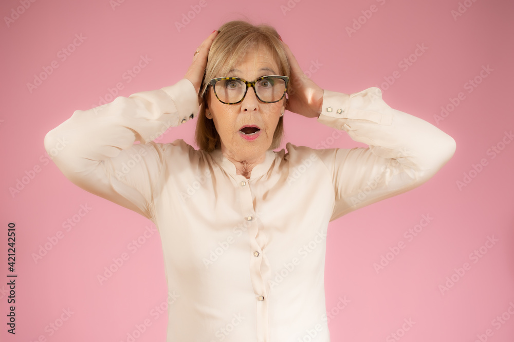 Surprised happy senior woman in elegant shirt isolated over pink background. Surprised happy senior woman in elegant shirt isolated over pink background.