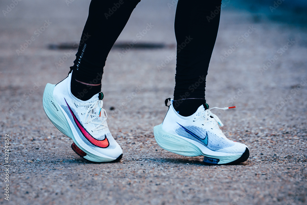 TOKYO, JAPAN, MARCH 18. 2021: Nike running shoes ALPHAFLY NEXT%.  Controversial athletics shoe on legs of professional athlete running on the  road. Official white shoe for Tokyo Olympics 2020 marathon Stock Photo |  Adobe Stock