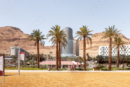 View of the beach on the Ein Bokek embankment on the coast of the Dead Sea  tourist hotels and sandy mountains in the background  in Israel