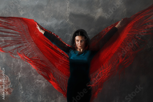 Young adult dancer woman dancing flamenco on gray vintage background