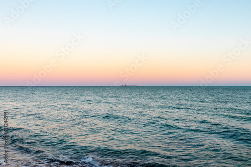Pastel colours on the horizon as the sun sets over the sea