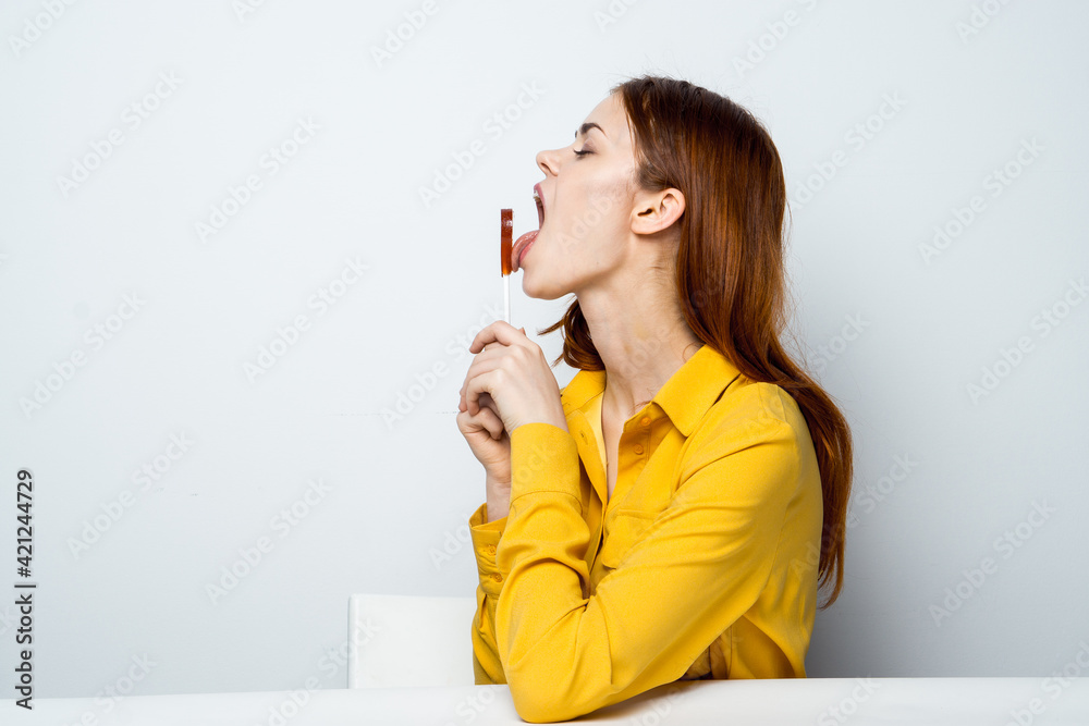 cheerful woman with heart shaped lollipop sitting at the table lifestyle cheerful woman with heart shaped lollipop sitting at the table lifestyle