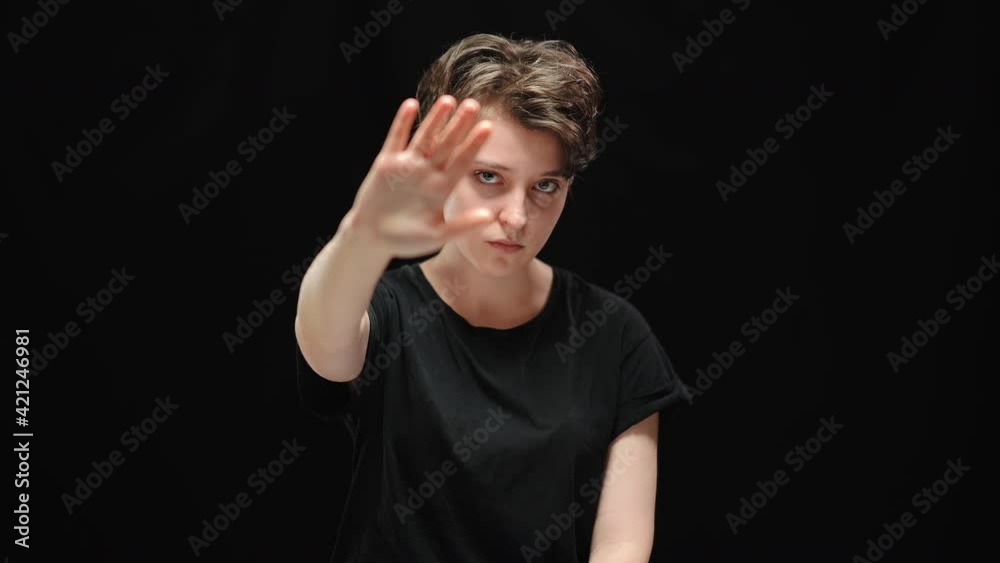 Sad serious brunette woman looking at camera and stretching hand. Portrait of upset stressed Caucasian lady posing at black background. Fear and scare concept. Sad serious brunette woman looking at camera and stretching hand. Portrait of upset stressed Caucasian lady posing at black background. Fear and scare concept.
