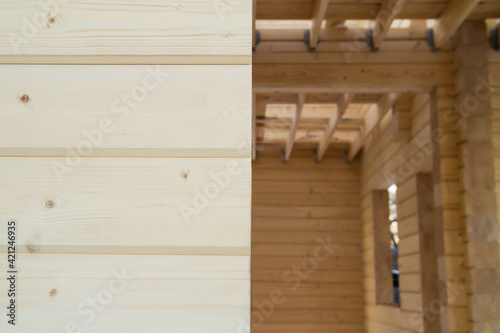 Unfinished ecological wooden house from a wooden beam. House wall made from glued pine beam. House construction from lumber.