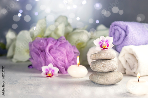 massage stones  burning candles  rolled towels  flowers  abstract lights. Spa resort therapy composition