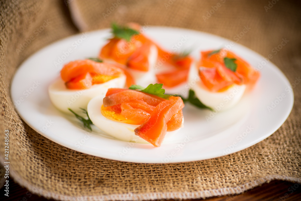 halves of boiled eggs with pieces of salted salmon halves of boiled eggs with pieces of salted salmon