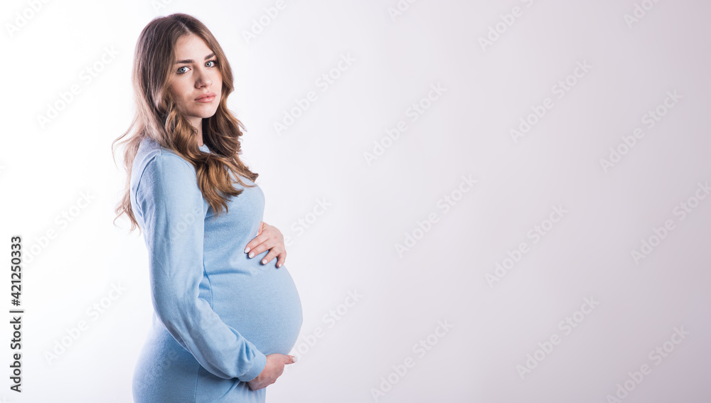 Portrait of a pregnant girl in the studio on a white background with copyspace Portrait of a pregnant girl in the studio on a white background with copyspace