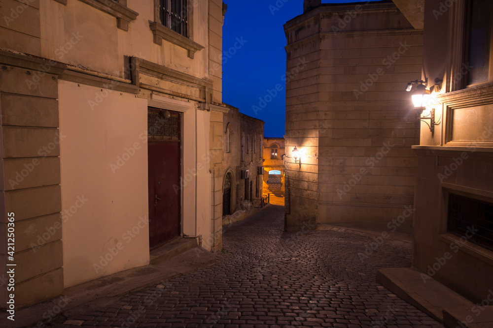 narrow street in the old town at night with lights 