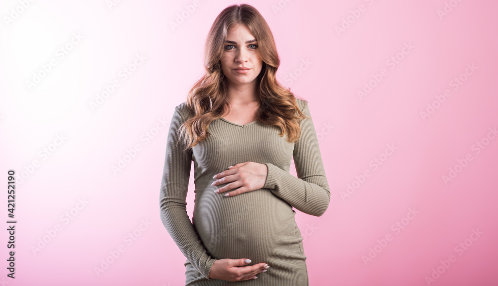 Portrait of a pregnant girl in the studio on a pink background Portrait of a pregnant girl in the studio on a pink background