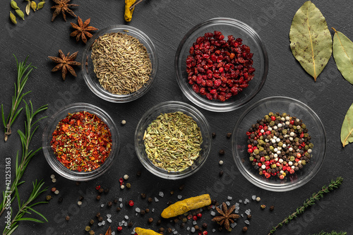 various spices on a gray background. seasoning in glass cups top view, close-up