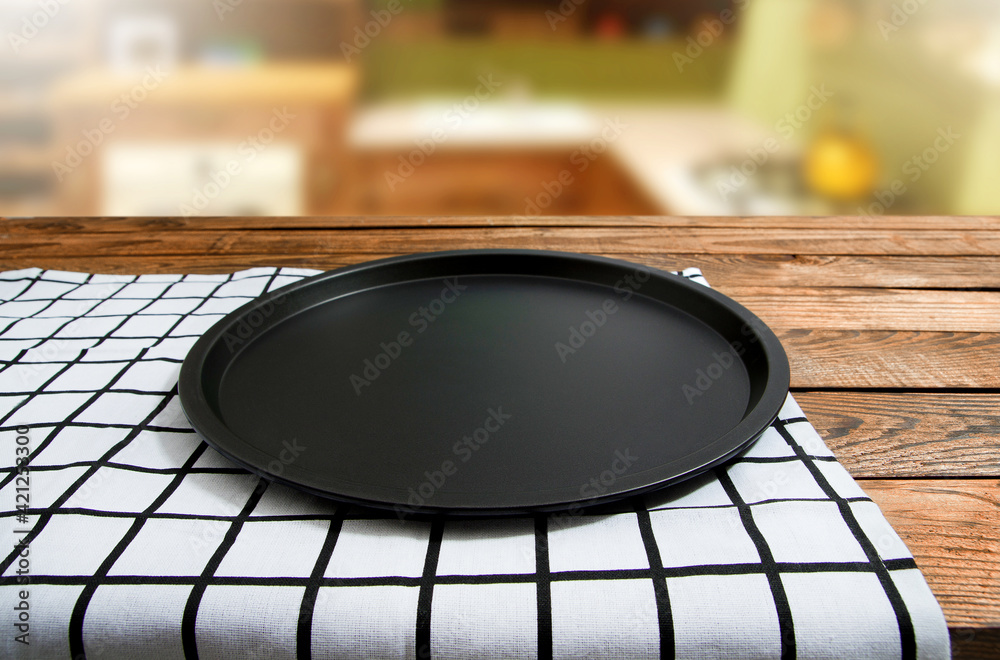 Baking dish. Plaid tablecloth on brown wooden table. Kitchen blured background. Mock up and top view. Copy space, empty place for food. Thanksgiving day. Pie dessert clean bakery form. Selective focus Baking dish. Plaid tablecloth on brown wooden table. Kitchen blured background. Mock up and top view. Copy space, empty place for food. Thanksgiving day. Pie dessert clean bakery form. Selective focus