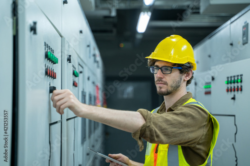 Electrical engineer checking status switchgear electrical energy distribution substation in factory.