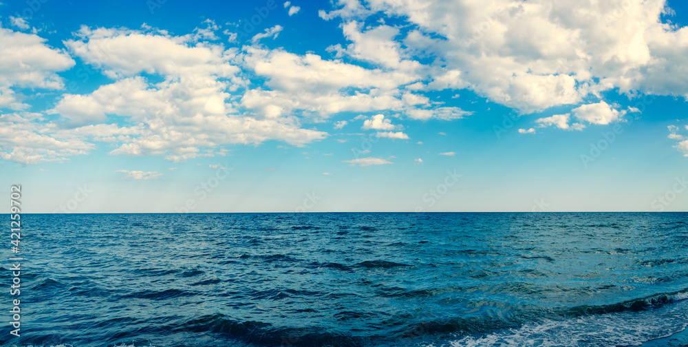 Seascape panorama wavy blue sea and sky with clouds