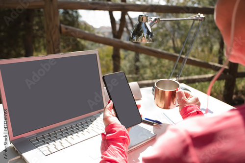 Fotografie woman with phone in hand, outdoor influencer work table with computer, and office supplies