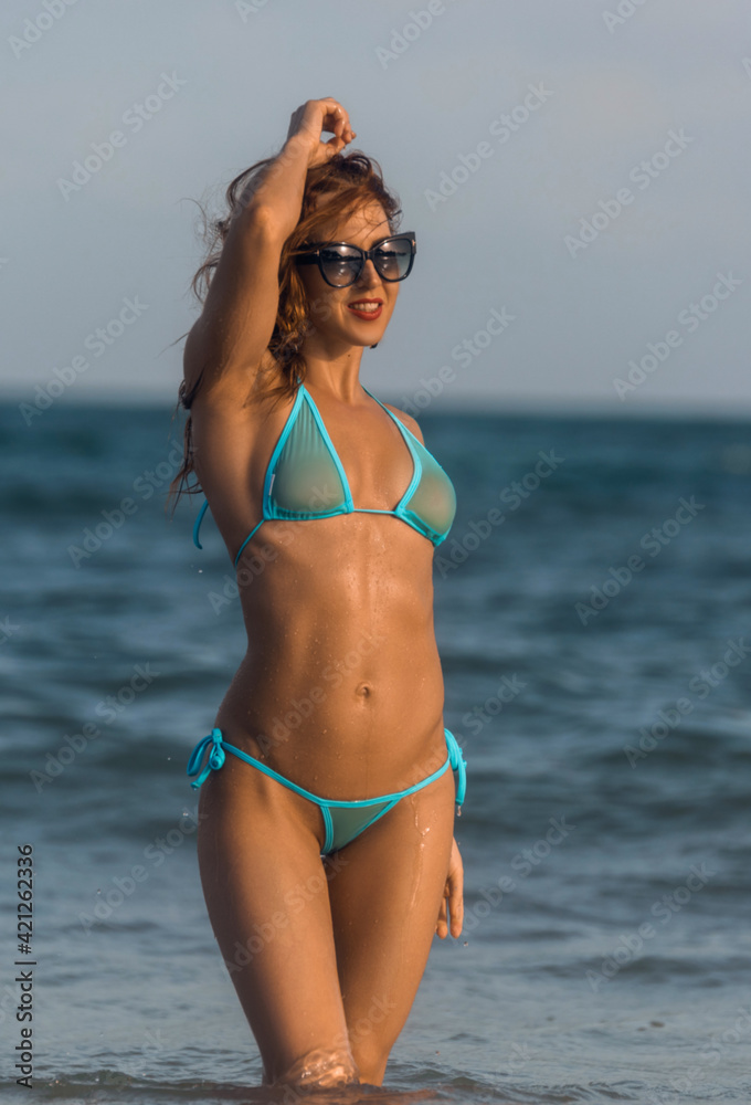 Attractive slim teenager girl in bikini runs along the beach Stock Photo