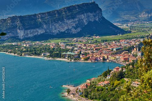 Fototapeta Naklejka Na Ścianę i Meble -  Panoramic view on Lake Garda from the Busatte-Tempesta trail near Nago-Torbole with the iron staircase,  Torbole  town surrounded by mountains in the summer time,Italy