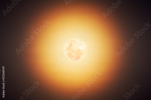 Fototapeta Naklejka Na Ścianę i Meble -  The moon shines with radiant yellow and orange in the night