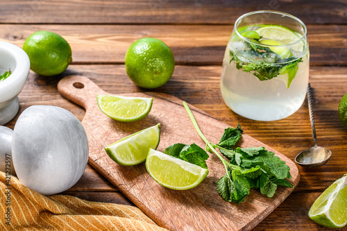 Mojito cocktail making. Ingredients  Mint, lime, ice and bar utensils. Wooden background. Top view