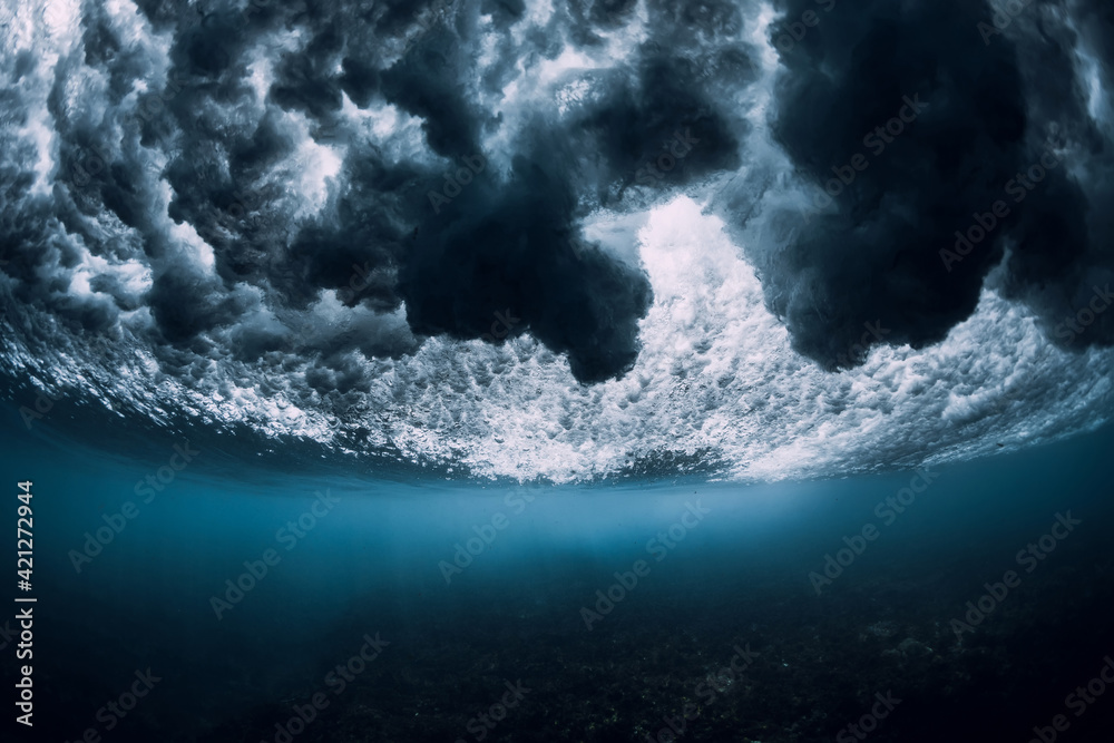 Wave underwater with foam, bubbles and sun light. Transparent ocean in underwater